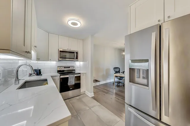 a kitchen with granite countertop stainless steel appliances and wooden cabinets