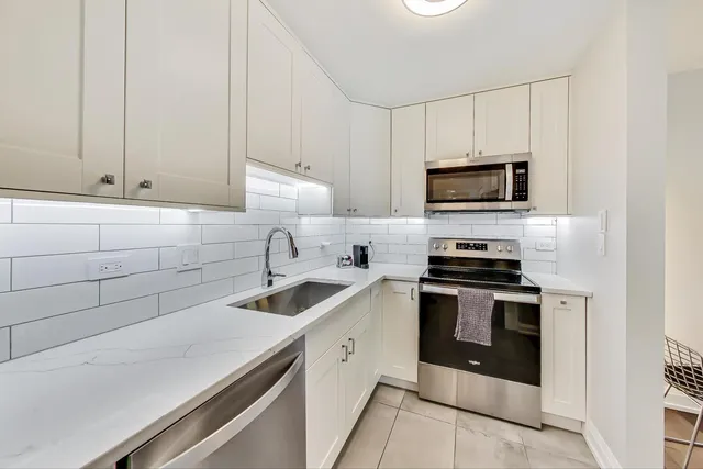 a kitchen with cabinets stainless steel appliances and a sink