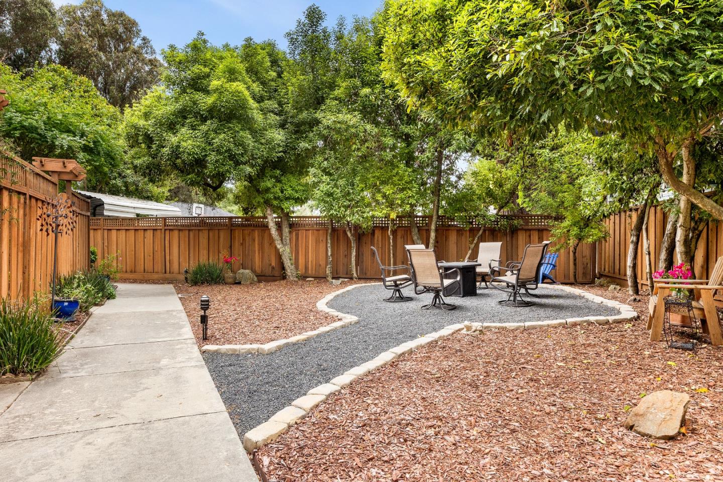 1644 Ocean Street Santa Cruz, CA 95060 - Photo 40 of 60 a view of a patio with a table and chairs under an umbrella with wooden fence