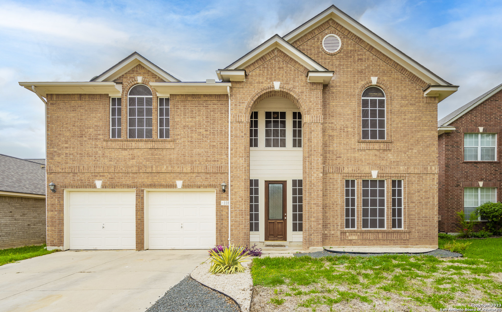 a front view of a house with a yard and garage