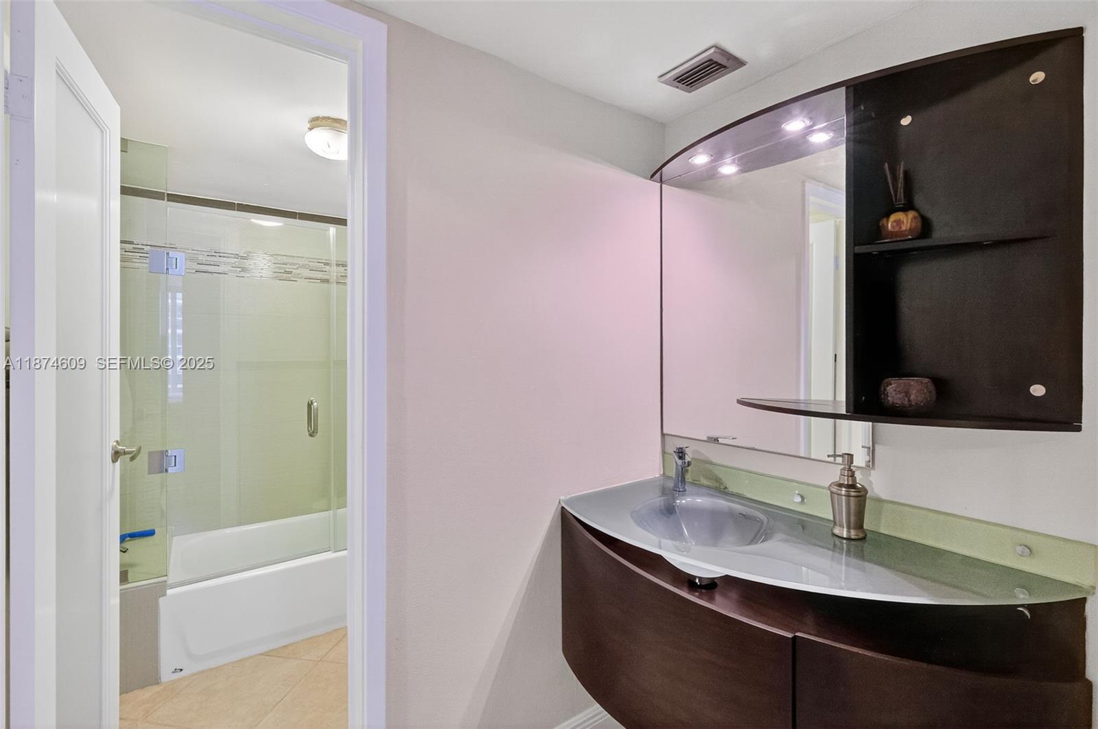 2401 Collins Avenue, Unit 1005 Miami Beach, FL 33140 - Photo 13 of 19 a bathroom with a granite countertop sink a mirror and shower