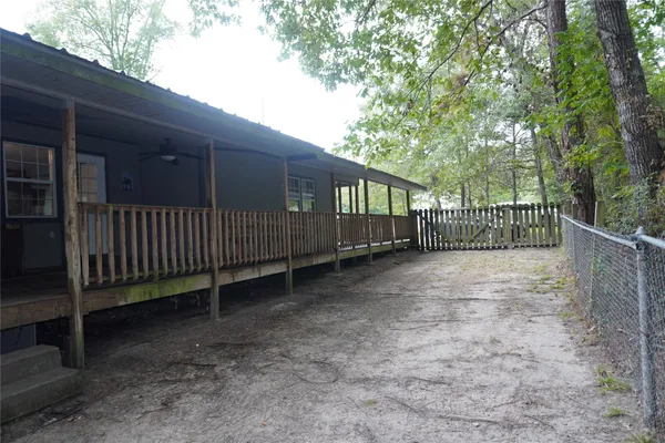 a view of a yard with wooden fence and trees