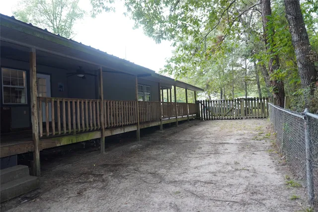 a view of a yard with wooden fence and trees