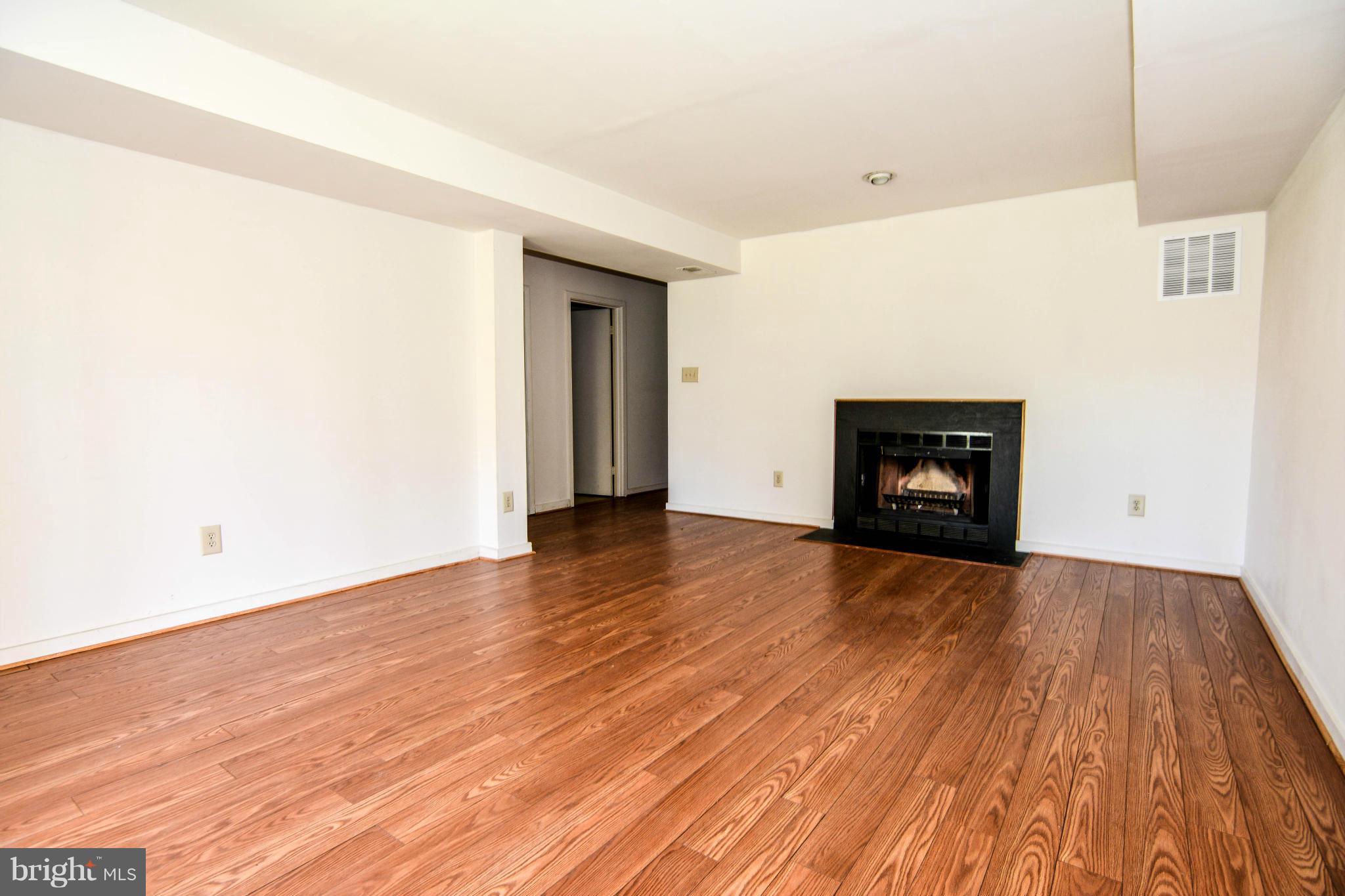 2237 Cedar Cove Court Reston, VA 20191 - Photo 24 of 27 a view of an empty room with wooden floor fireplace and a window