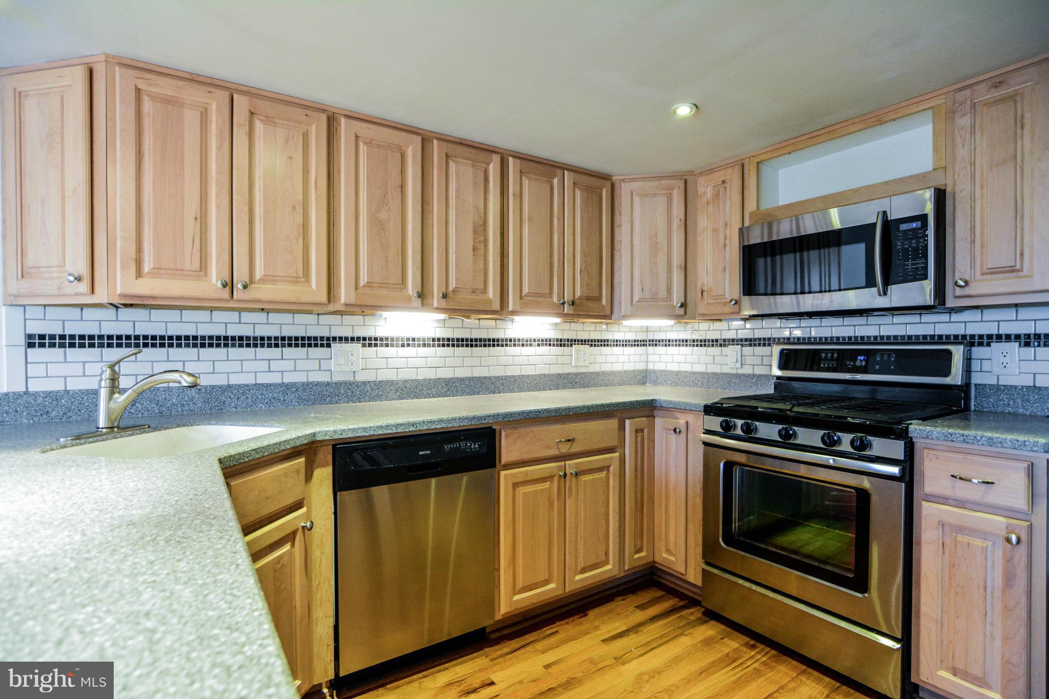 2237 Cedar Cove Court Reston, VA 20191 - Photo 4 of 27 a kitchen with granite countertop wood cabinets stainless steel appliances and a sink
