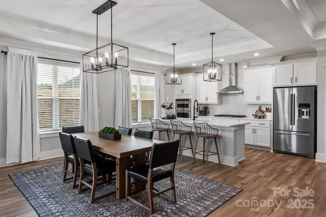 a kitchen with a dining table chairs stainless steel appliances and cabinets