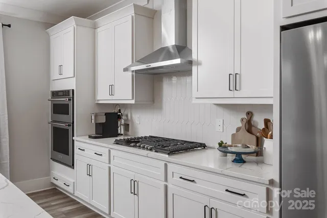 a kitchen with stainless steel appliances granite countertop a refrigerator and a stove