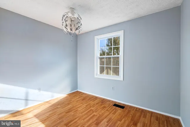 a view of a big room with wooden floor and a chandelier