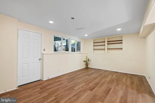 a view of empty room with wooden floor
