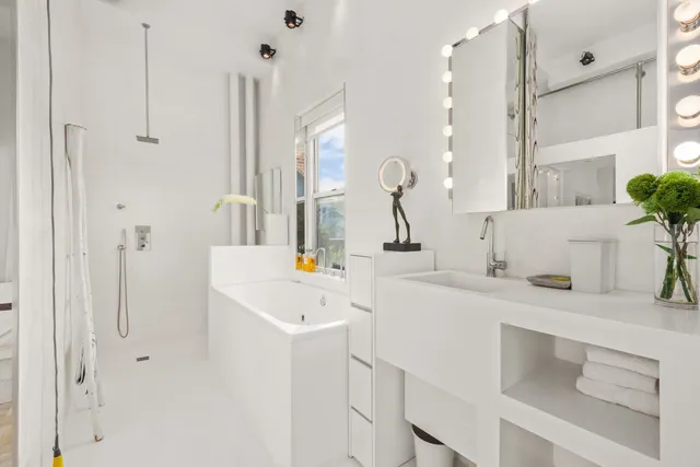 a bathroom with a sink and a mirror with bathtub