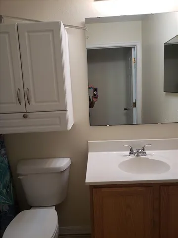 a bathroom with a sink toilet and mirror