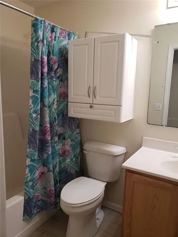a bathroom with a toilet a sink and curtain