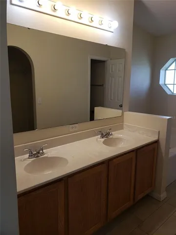 a bathroom with a double vanity sink and a mirror