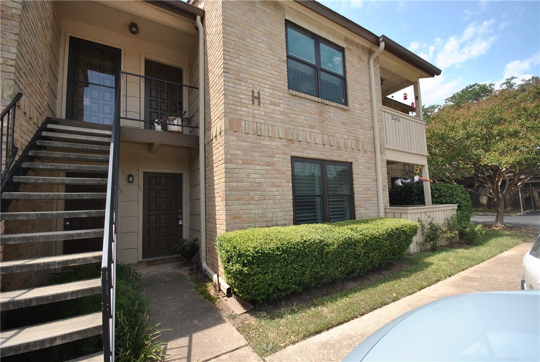a view of a house with a yard and large tree