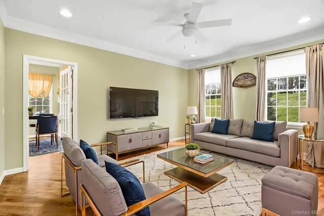 a living room with furniture a flat screen tv and a large window