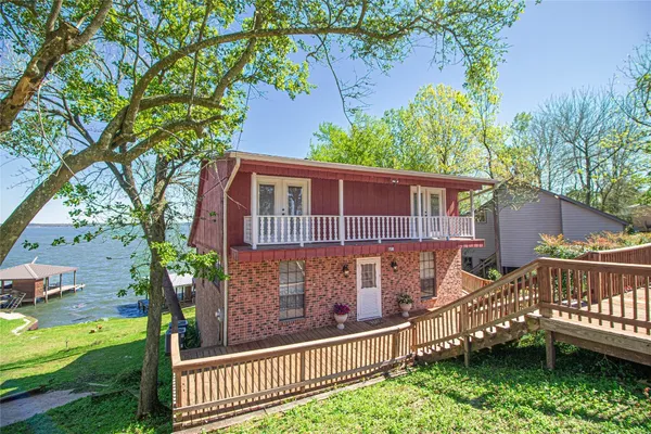 a view of a house with wooden fence next to a yard