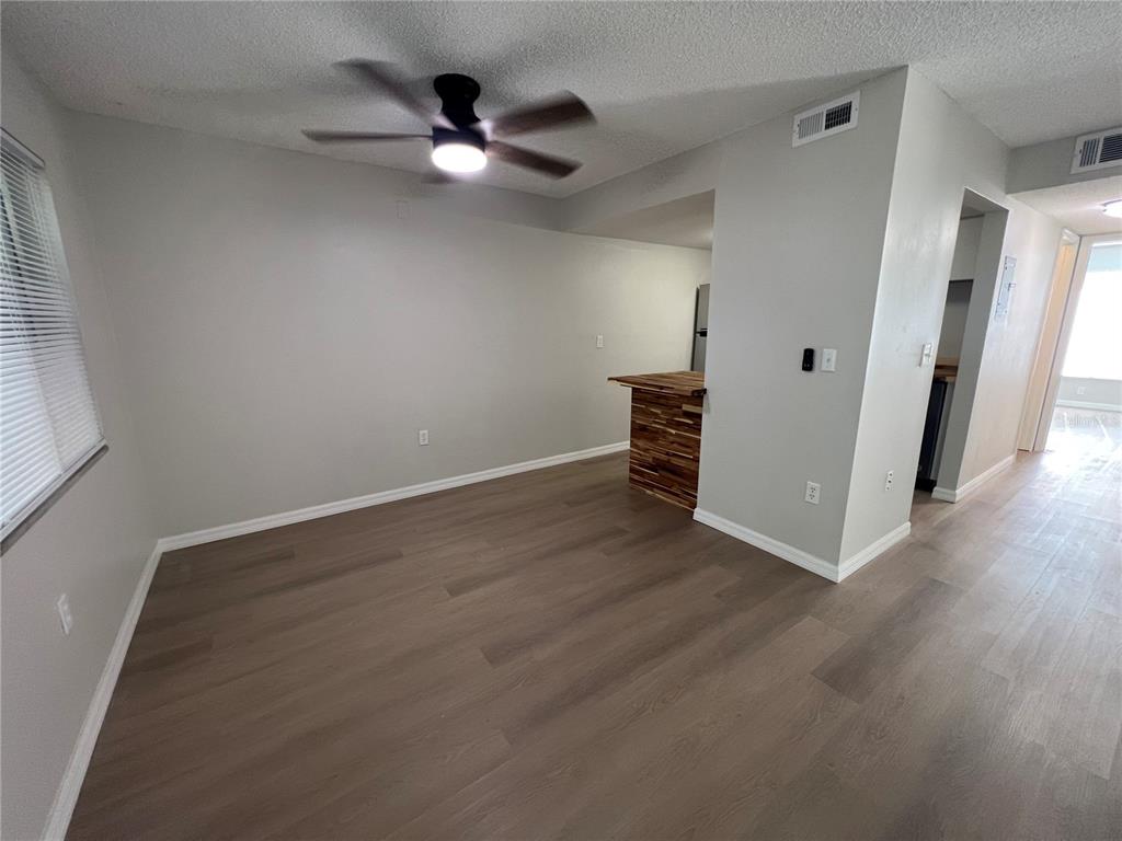 2611 Pine Lake Terrace, Unit B Sarasota, FL 34237 - Photo 7 of 21 an empty room with wooden floor and fan