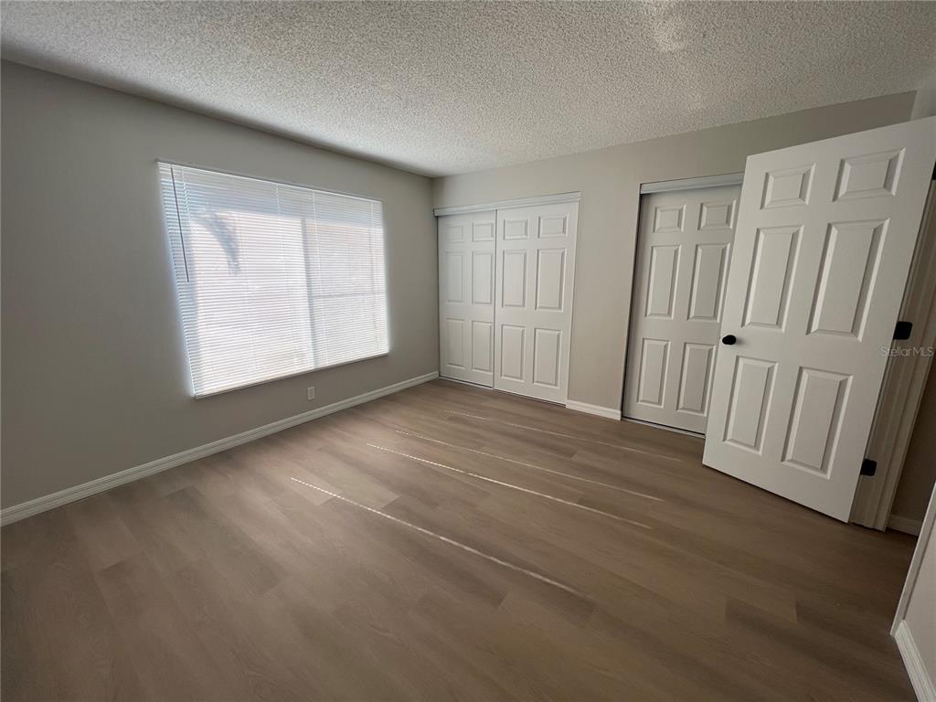 2611 Pine Lake Terrace, Unit B Sarasota, FL 34237 - Photo 8 of 21 an empty room with wooden floor and windows