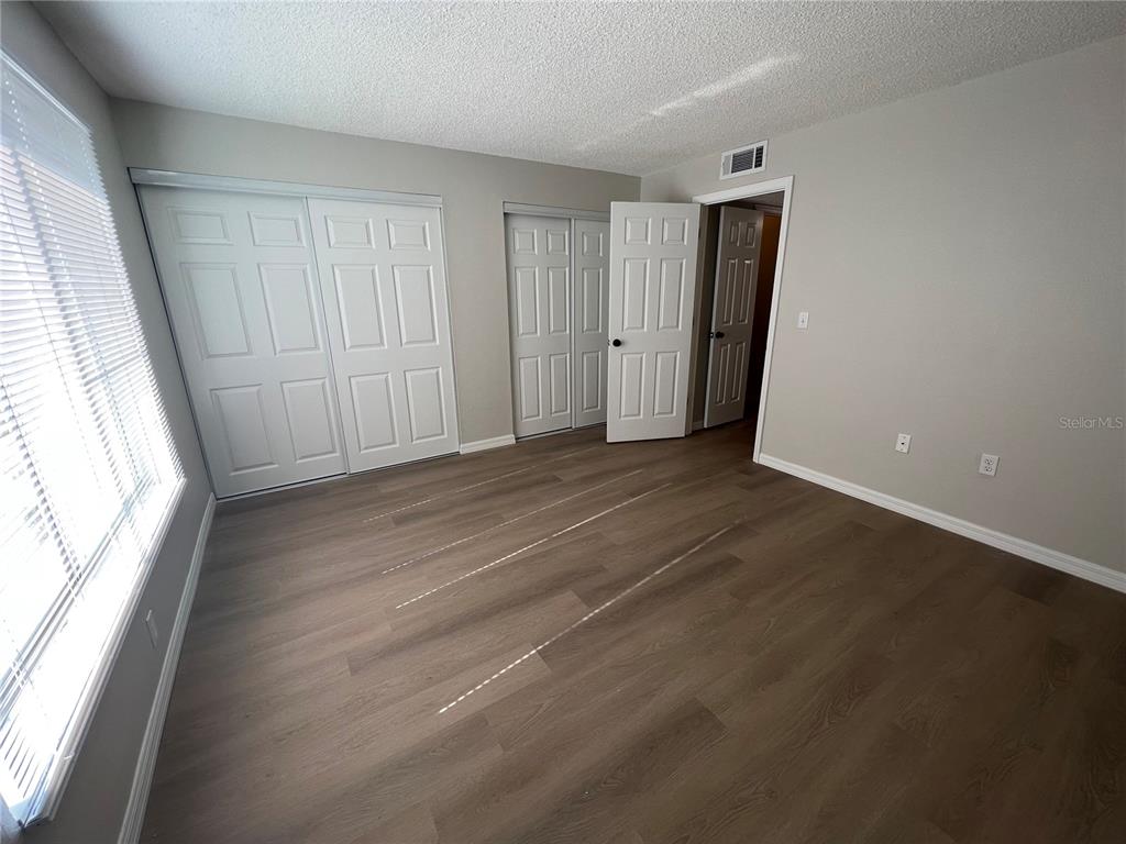 2611 Pine Lake Terrace, Unit B Sarasota, FL 34237 - Photo 10 of 21 an empty room with wooden floor and windows