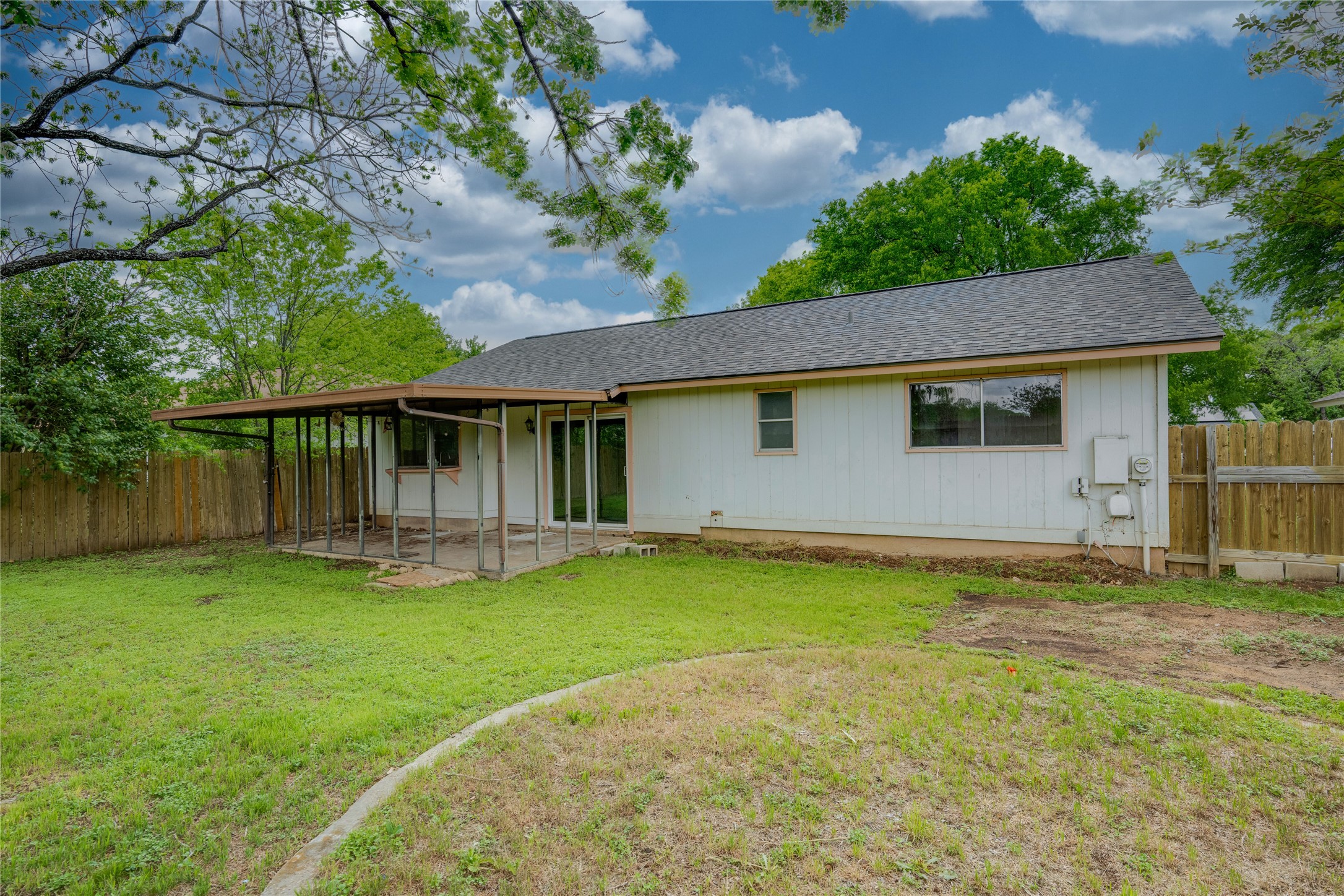 4811 Brushy Ridge Drive Austin, TX 78744 - Photo 12 of 39 Rear view of house featuring a fenced backyard, a shingled roof, and a patio