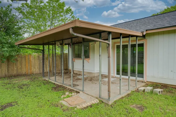 a backyard of a house with table and chairs