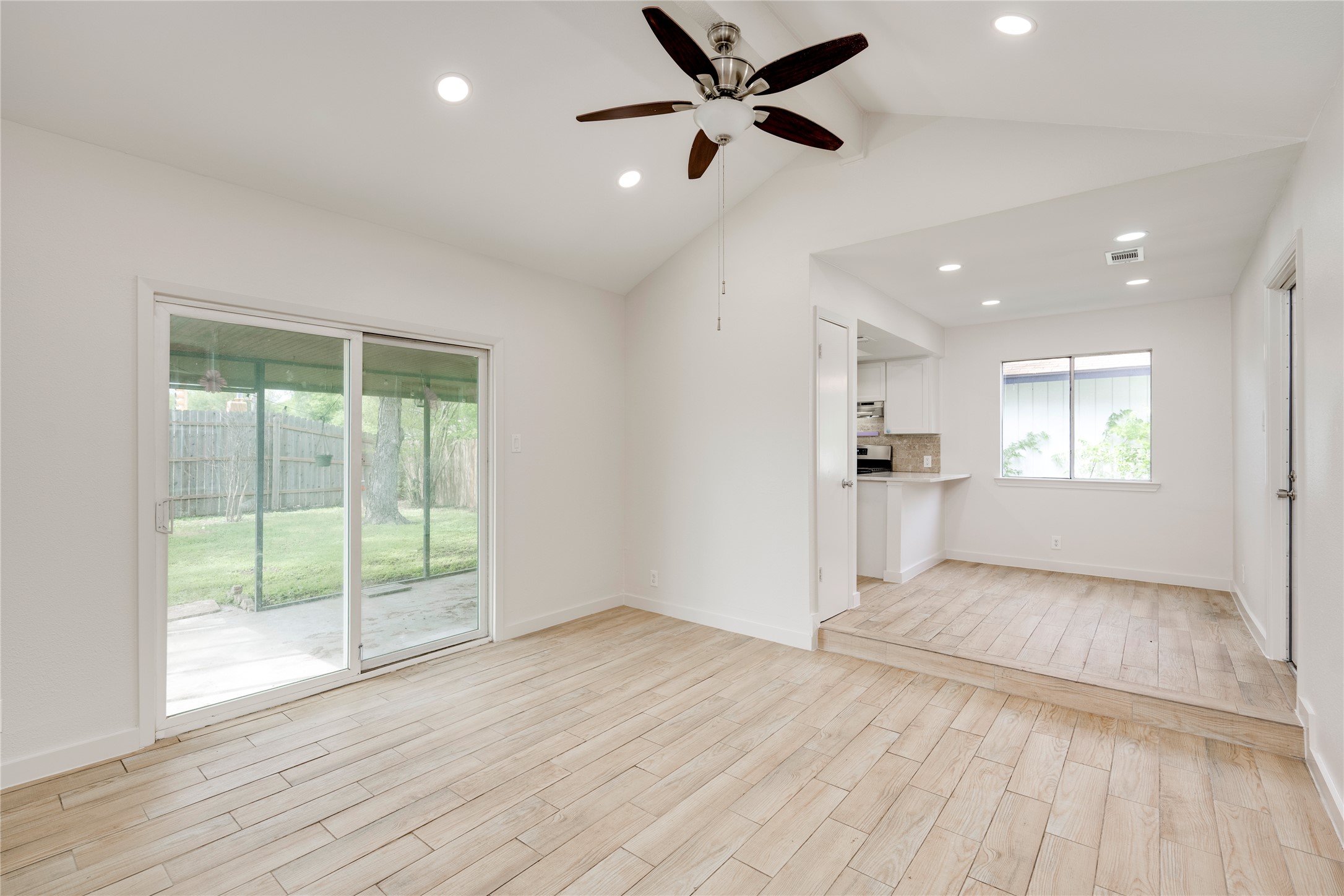 4811 Brushy Ridge Drive Austin, TX 78744 - Photo 16 of 39 Unfurnished living room with lofted ceiling, ceiling fan, wood finish floors, and recessed lighting