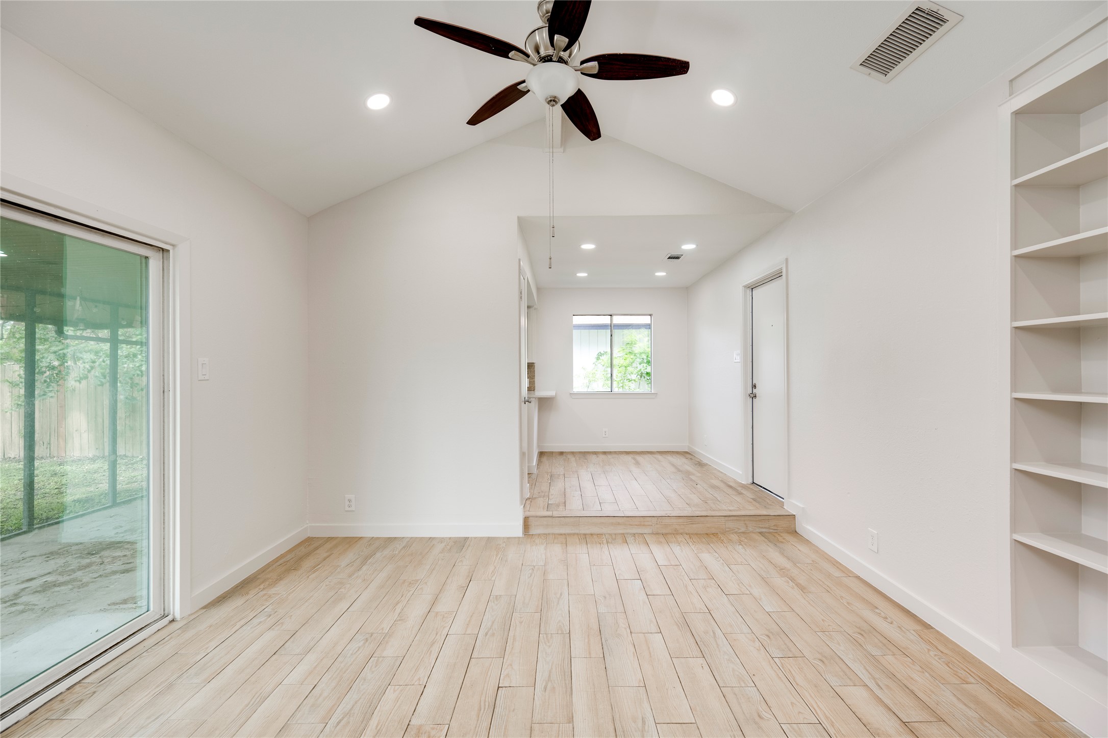 4811 Brushy Ridge Drive Austin, TX 78744 - Photo 17 of 39 Empty room featuring wood finish floors, ceiling fan, and built in features
