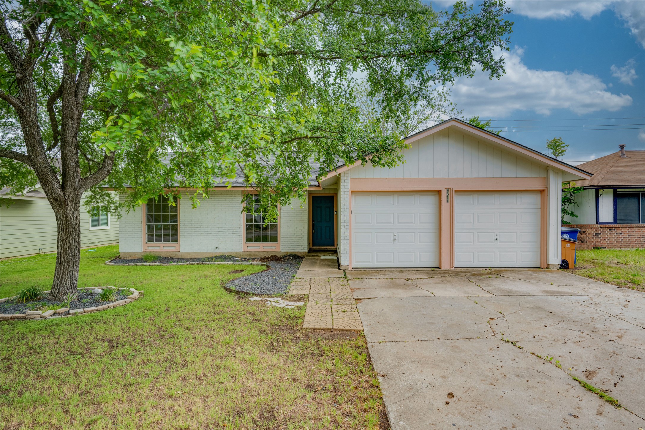 4811 Brushy Ridge Drive Austin, TX 78744 - Photo 2 of 39 Ranch-style home featuring brick siding, concrete driveway, a front lawn, and a garage