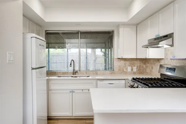 a kitchen with stainless steel appliances a sink stove and cabinets