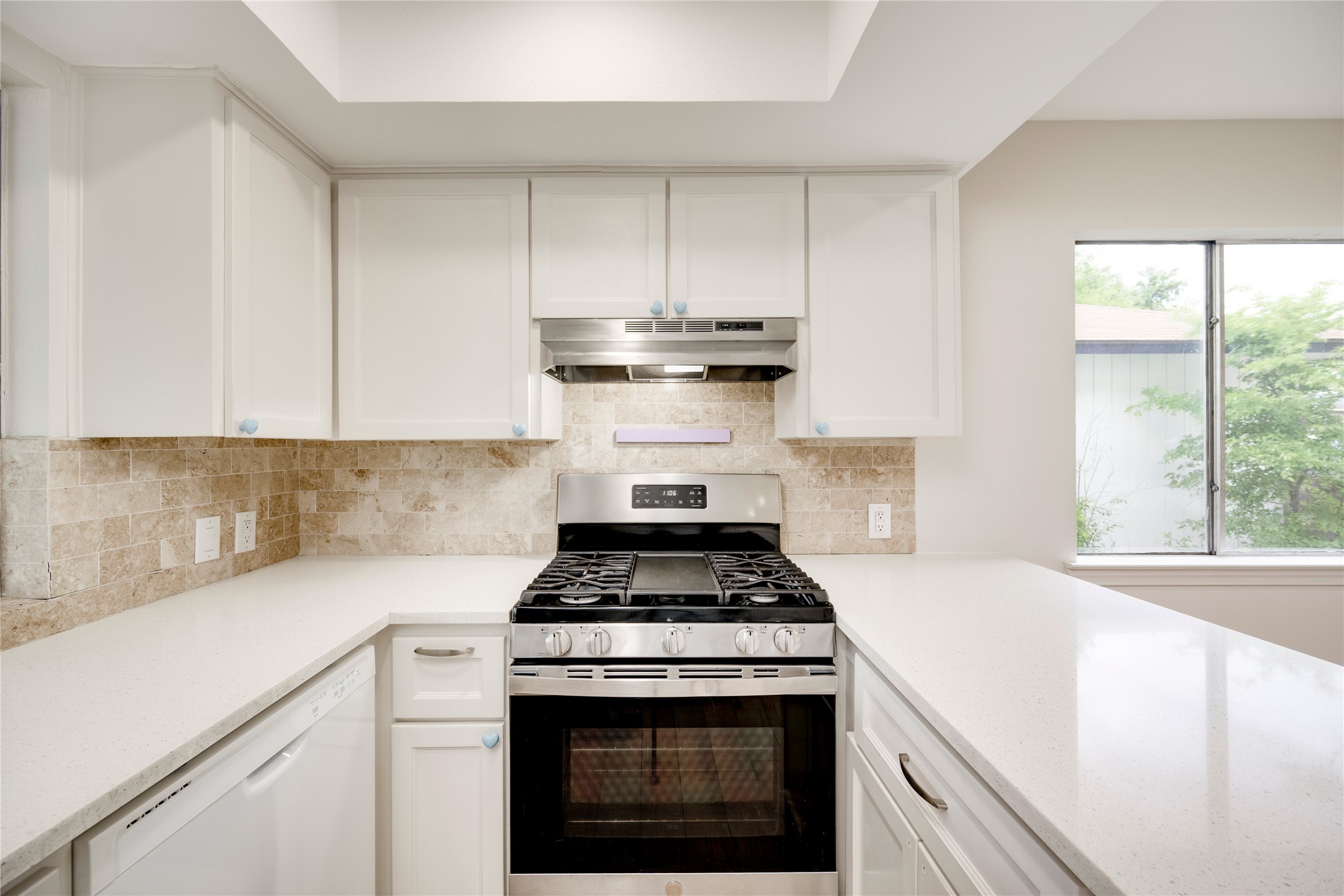 4811 Brushy Ridge Drive Austin, TX 78744 - Photo 28 of 39 Kitchen with gas stove, white dishwasher, and white cabinets