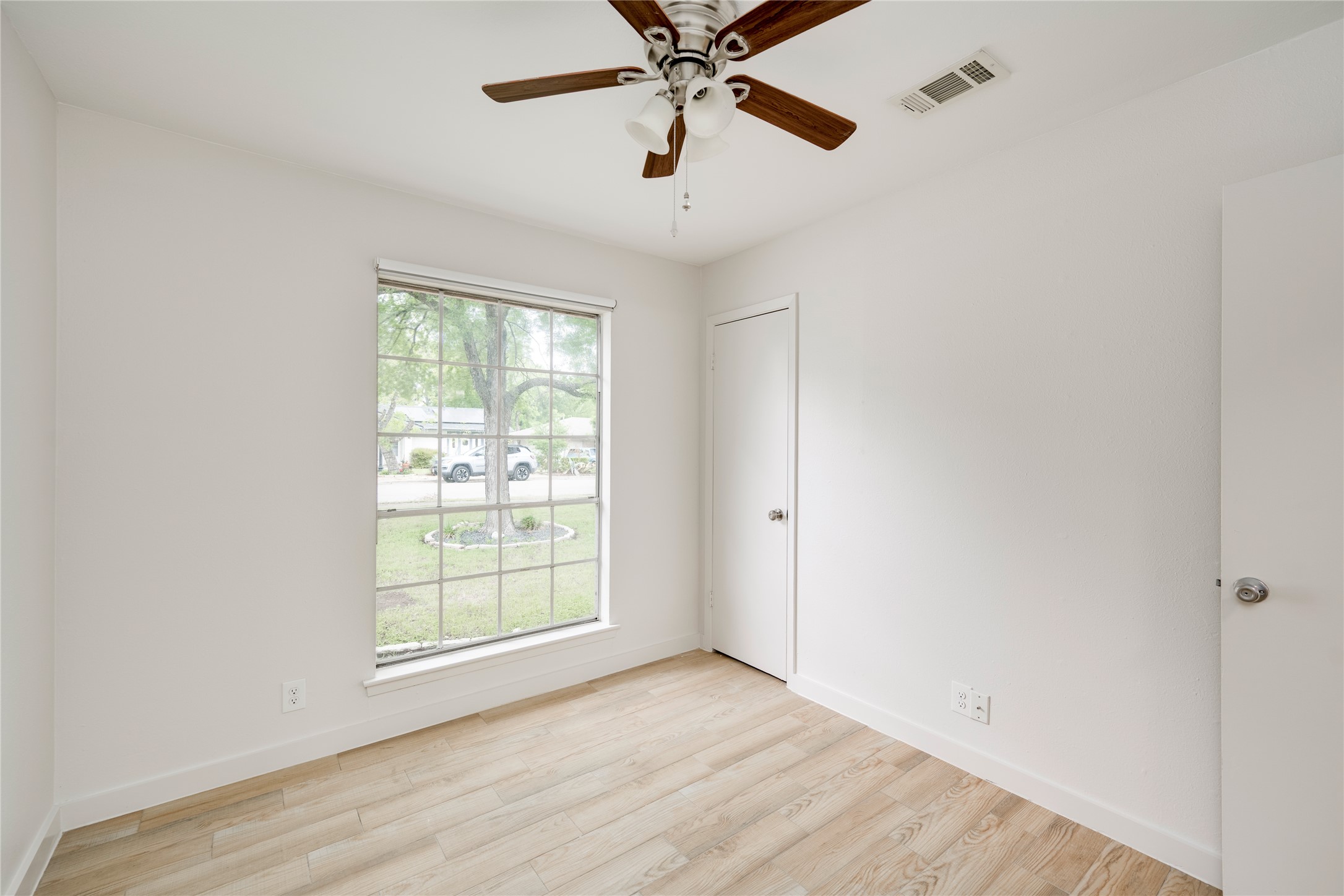 4811 Brushy Ridge Drive Austin, TX 78744 - Photo 30 of 39 Unfurnished room with light wood-style floors and a ceiling fan