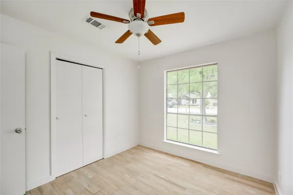 an empty room with fan and windows