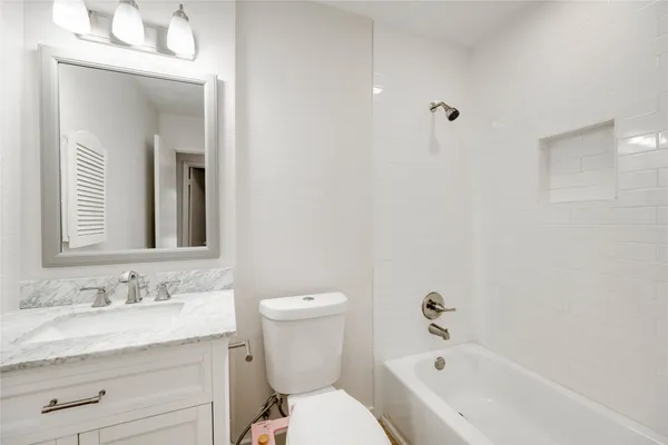 a bathroom with a granite countertop sink toilet and shower