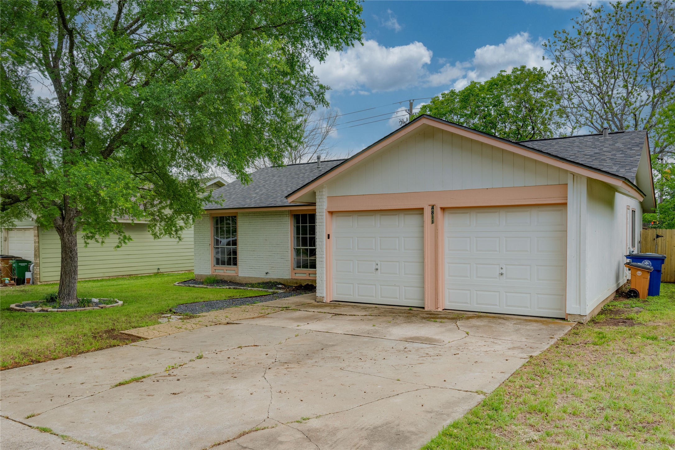 4811 Brushy Ridge Drive Austin, TX 78744 - Photo 4 of 39 Ranch-style house with a shingled roof, a front lawn, a garage, and concrete driveway