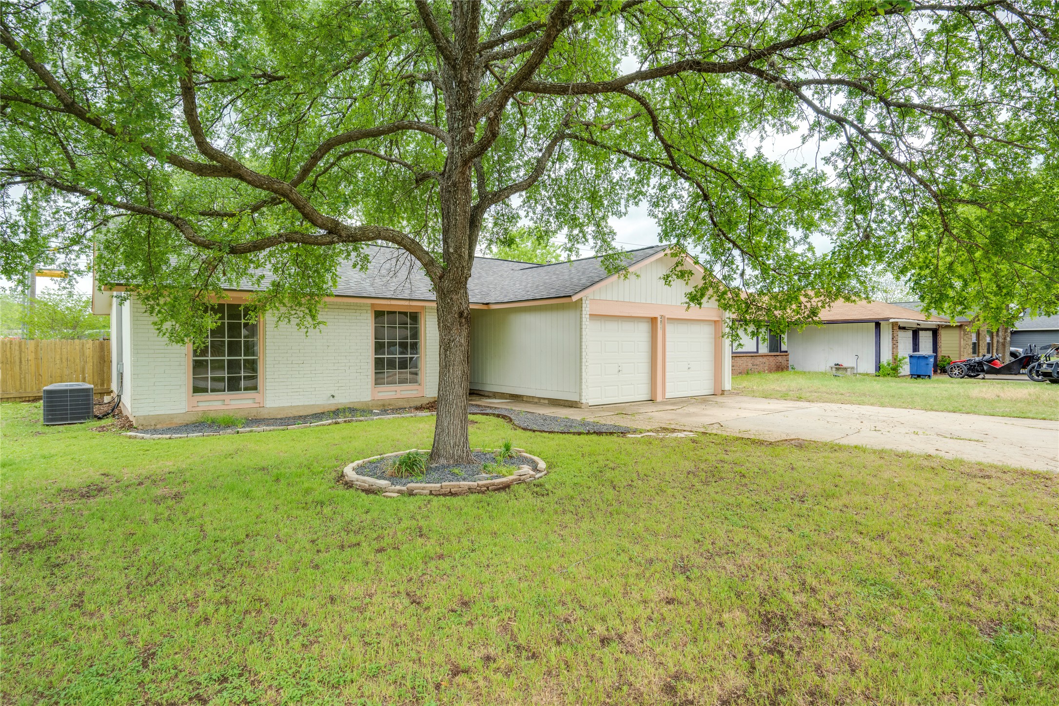 4811 Brushy Ridge Drive Austin, TX 78744 - Photo 5 of 39 Single story home featuring driveway, an attached garage, a front lawn, brick siding, and a shingled roof