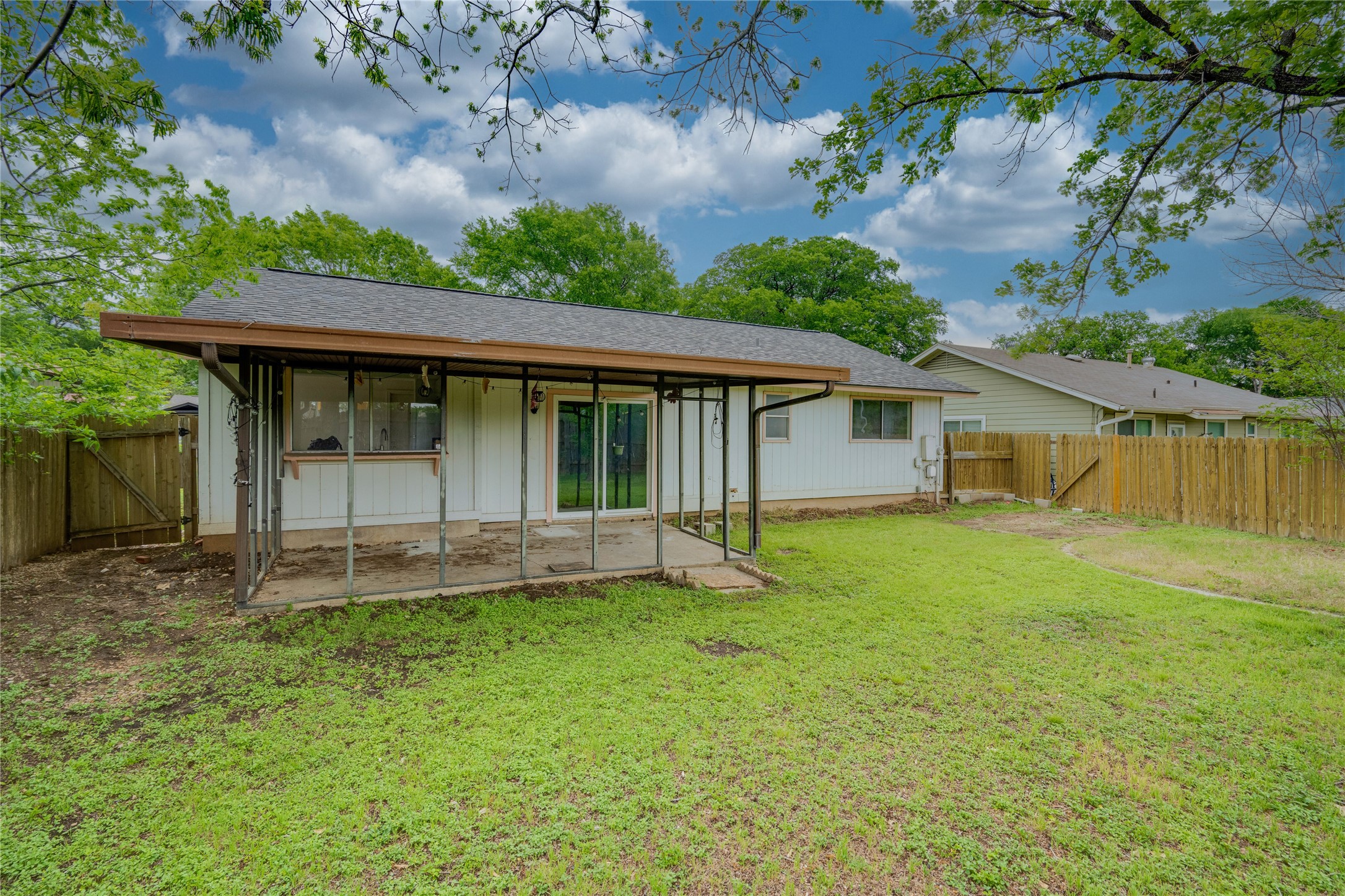 4811 Brushy Ridge Drive Austin, TX 78744 - Photo 10 of 39 Back of property featuring a gate, a shingled roof, a fenced backyard, and board and batten siding