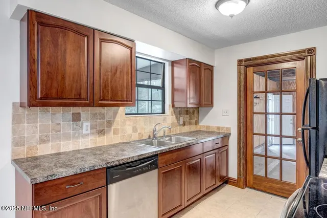 a kitchen with stainless steel appliances granite countertop a sink stove and cabinets