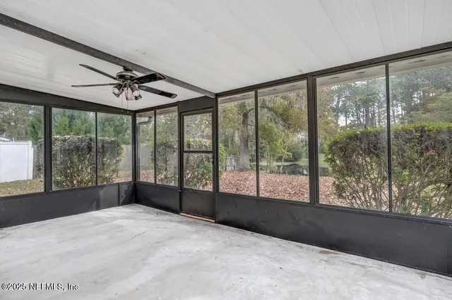 a view of a room with wooden floor and a ceiling fan