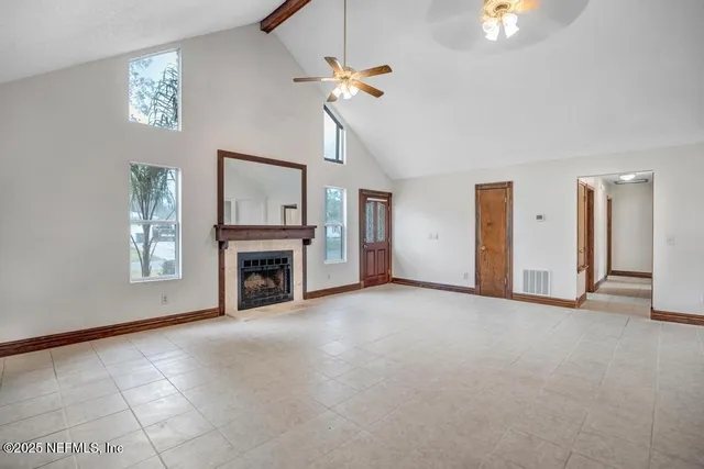 a view of empty room with fireplace and fan