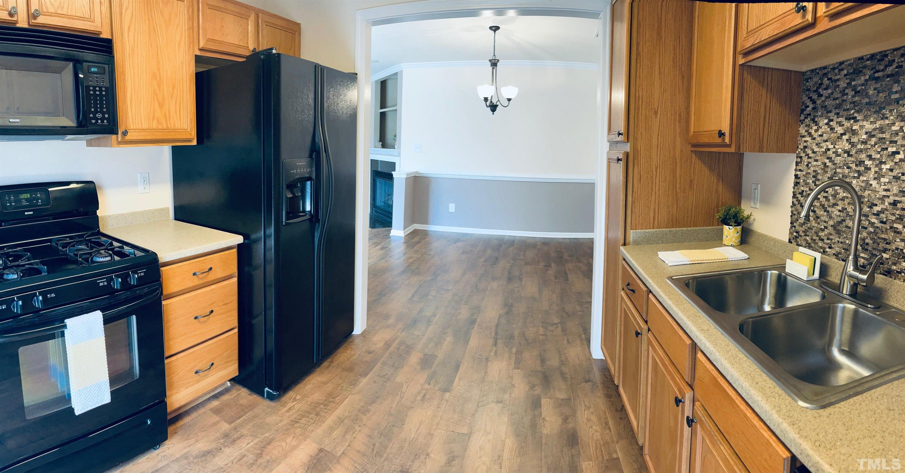 9817 Grettle Court Raleigh, NC 27617 - Photo 13 of 15 a kitchen with stainless steel appliances granite countertop a sink stove and refrigerator