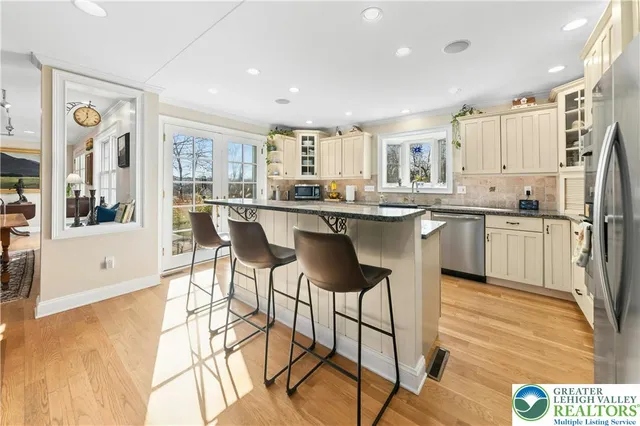 a kitchen with stainless steel appliances granite countertop a table and chairs in it