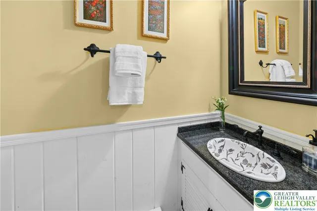 a bathroom with a granite countertop sink and a mirror