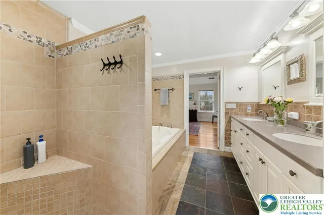 a bathroom with a double vanity sink a large mirror a shower and bathtub