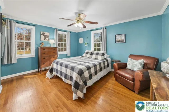 a bedroom with a bed wooden floor and window