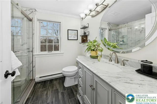 a spacious bathroom with a granite countertop sink a toilet a mirror and shower