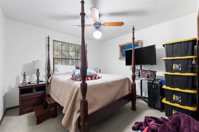 a bedroom with a bed a flat screen tv and a chandelier