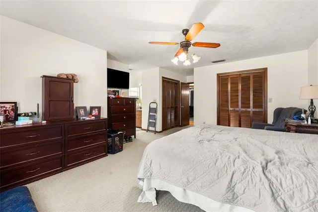 a bedroom with a bed and a flat tv screen on dresser