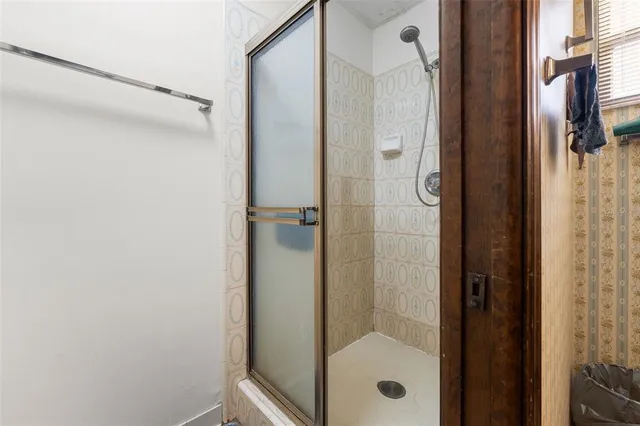 a bathroom with a glass shower door and mirror