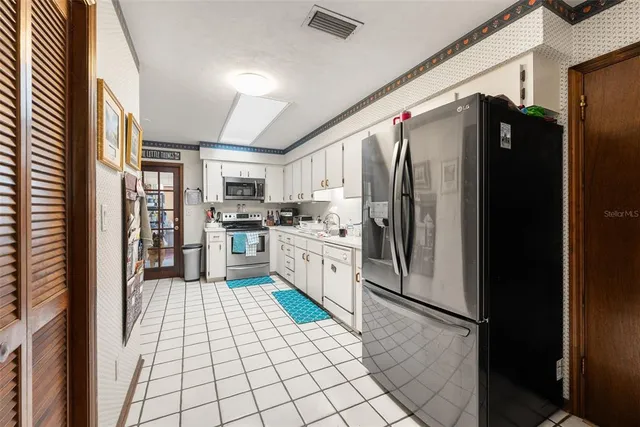 a kitchen with stainless steel appliances granite countertop a refrigerator and a stove top oven