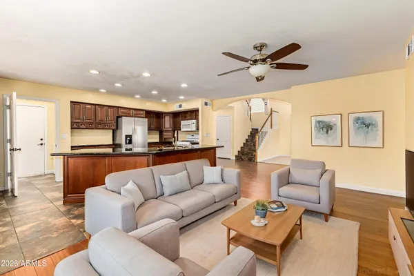 a living room with furniture kitchen view and a chandelier